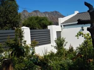 a white house with mountains in the background at Studio on Albert, Hout Bay in Hout Bay