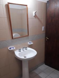 ein Badezimmer mit Waschbecken und Spiegel in der Unterkunft Hostal Rustyk in Cafayate + 50 Fotos