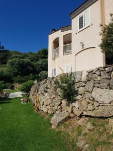 a stone retaining wall in front of a house at Résidence Assuliu in Propriano