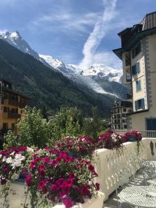 uma varanda com flores e vista para as montanhas em Grand Hôtel des Alpes em Chamonix-Mont-Blanc
