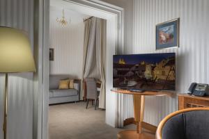 a living room filled with furniture and a painting on the wall at Hotel Pod Věží in Prague