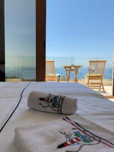 a bed with two towels on it with a view of the ocean at Villa Horus in Sveti Stefan