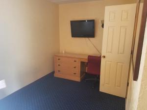 a small room with a television and a bed at La Casa Inn and Suites in Tallahassee