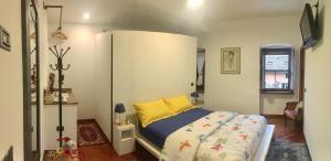 een slaapkamer met een bed met een geel kussen bij Guest House Santiago in Arco