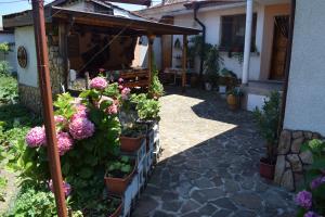 a garden with potted plants and flowers on a patio at Guest house Nedyalkovi in Chernomorets