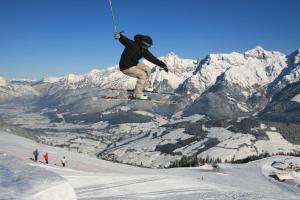 osoba skacząca w powietrzu na nartach w śniegu w obiekcie Alpine Cottage Salzburg w mieście Maria Alm am Steinernen Meer