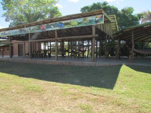 een paviljoen met tafels en stoelen in een park bij Pousada São João - Estrada Parque Pantanal in Corumbá