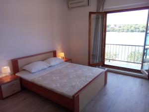 a bedroom with a bed and a large window at Trim Rooms and Apartments in Lovište