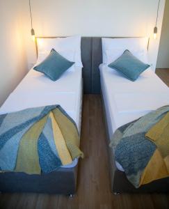 duas camas sentadas uma ao lado da outra num quarto em Soukki Town Centre Suites em Split