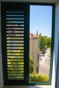 a window with a view of a street and a building at Soukki Town Centre Suites in Split