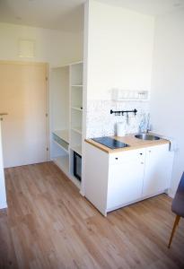 a kitchen with white cabinets and a sink at Soukki Town Centre Suites in Split
