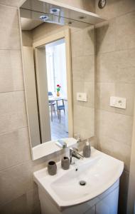 a bathroom with a sink and a mirror at Soukki Town Centre Suites in Split