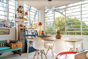 a room with white chairs and a table and windows at Paradiso Hostel & Suites - TOP 1 DE SÃO PAULO in São Paulo