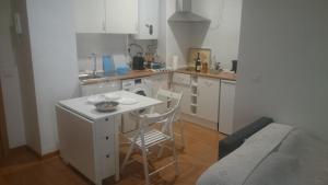 uma cozinha com mesa e cadeiras num quarto em Casa de George em Málaga