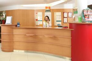 a woman standing in front of a counter in a store at Hotel ibis Setubal in Setúbal