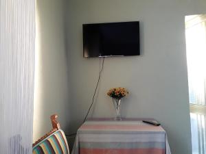 Habitación con mesa y TV en la pared. en Mulberry Home, en Likotinaréa