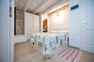 a bedroom with a bed and a brick wall at Apartments CASA ROCCIA BIANCA in Rovinj