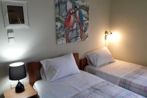 1 dormitorio con 2 camas, lámpara y una foto en Mulberry Home, en Likotinaréa
