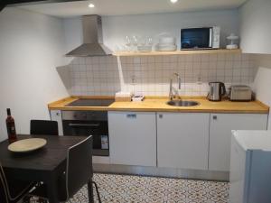 eine Küche mit einer Spüle und einer Mikrowelle in der Unterkunft Cassiopeia Duplex in Setúbal