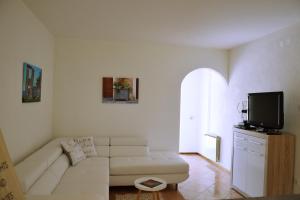 a living room with a white couch and a tv at Apartment Istrian view in Šmarje