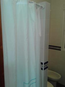 a white shower curtain in a bathroom with a toilet at LA ERA 30 in Bolonia