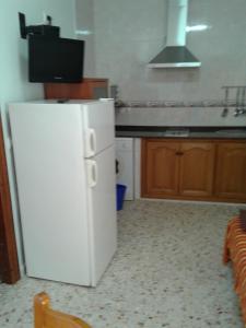 a kitchen with a white refrigerator and a sink at LA ERA 30 in Bolonia