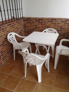 a white table and chairs sitting next to a brick wall at LA ERA 30 in Bolonia