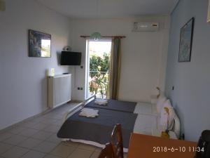 a bedroom with a bed and a table and a window at Alexandra Apartments in Stoupa