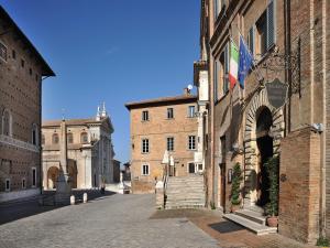 Une allée dans un vieux bâtiment avec deux bâtiments dans l'établissement Albergo San Domenico, à Urbino