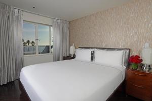 a large white bed in a bedroom with a window at Hotel Shangri-La in Los Angeles