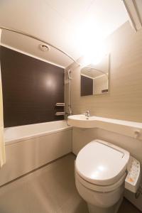 
a white toilet sitting next to a white sink at Dormy Inn Premium Shibuya-jingumae in Tokyo
