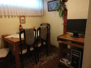 um quarto com 2 cadeiras e uma secretária com uma televisão em Apart Hotel Aleman em Puerto Montt