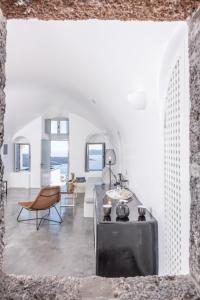 - un salon avec des murs blancs et une table dans l'établissement NK Cave House Villa, à Fira