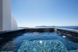 a swimming pool with the ocean in the background at NK Cave House Villa in Fira