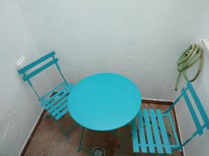 een blauwe tafel en twee stoelen naast een muur bij Casas do Megué in Évora