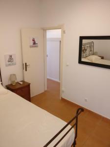- une chambre avec un lit et un miroir mural dans l'établissement Casas do Megué, à Évora