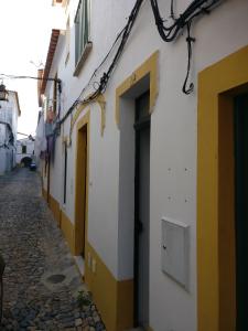 Une ruelle étroite avec des bâtiments jaunes et blancs dans l'établissement Casas do Megué, à Évora