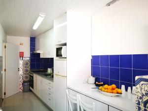 a kitchen with a bowl of oranges on a counter at Peniche's Blue & White in Peniche