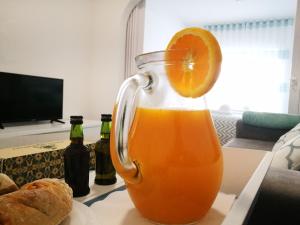 a glass pitcher of orange juice with an orange slice at Peniche's Blue & White in Peniche