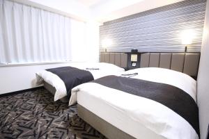 Cette chambre comprend 2 lits et une fenêtre. dans l'établissement APA Hotel Hikoneminami, à Hikone