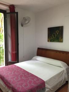 a bedroom with a bed with a purple blanket at Pensión Teruel in Barcelona