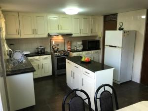 a kitchen with white cabinets and a white refrigerator at Villa San José in Arequipa