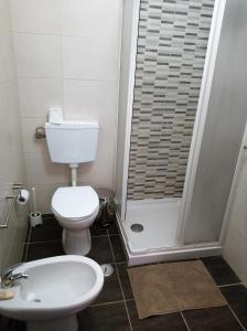 a white toilet sitting in a bathroom next to a sink at Sleep & Go Faro Airport Guest House in Faro
