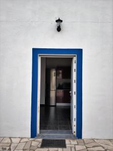 una porta blu che conduce in una stanza con parete bianca di Sleep & Go Faro Airport Guest House a Faro