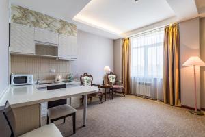 a kitchen and living room with a table and chairs at Lenina Hotel in Yuzhno-Sakhalinsk