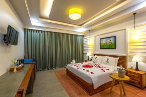 a bedroom with a large bed with red roses on it at The Tito Suite Residence in Siem Reap