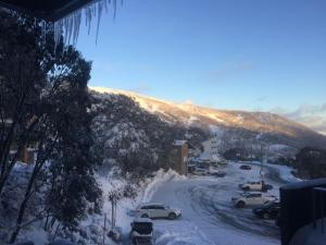 a street covered in snow with cars parked on it at St Falls West 101 in Falls Creek