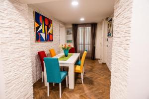 une salle à manger avec une table blanche et des chaises colorées dans l'établissement AVG CityCenter Apartments, à Palerme