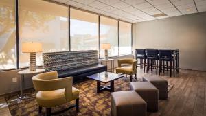 a waiting room with a couch and chairs and windows at Hotel Pentagon in Arlington