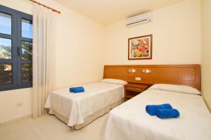 dwa łóżka w pokoju z oknem w obiekcie Sun Grove Villas & Spa w mieście Playa Blanca +21 zdjęć